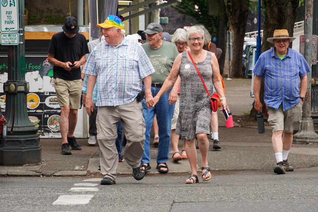 Mary Lou Hennrich walks from a bus stop in Downtown Portland with the rest of the Tabor to Town group.,