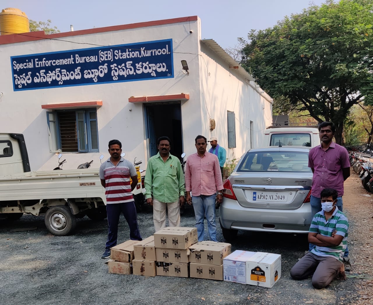ముద్దాయి, మద్యం సీసాలను పట్టుకున్న సెబ్​ పోలీసులు