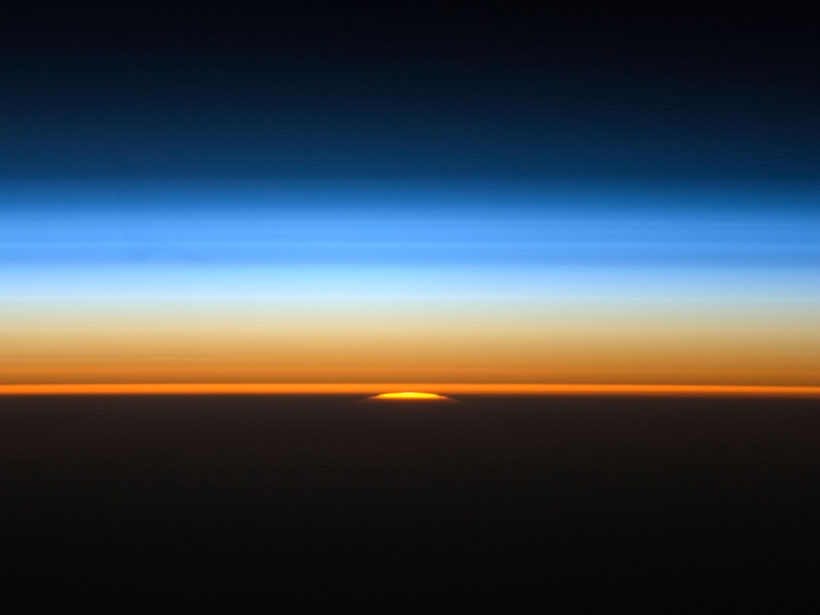 The setting Sun illuminates the layers of Earth’s atmosphere in this view from the International Space Station.