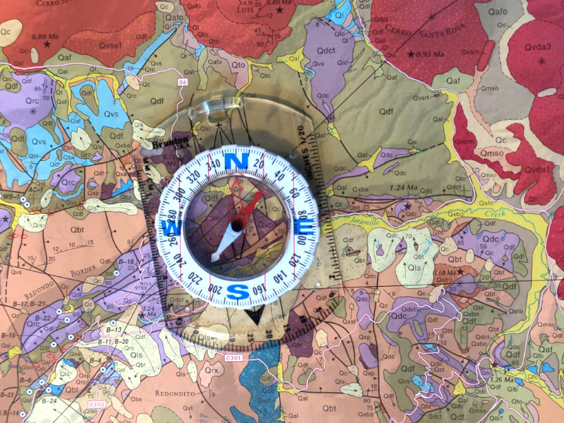 Traditional low-tech compass on a geologic map
