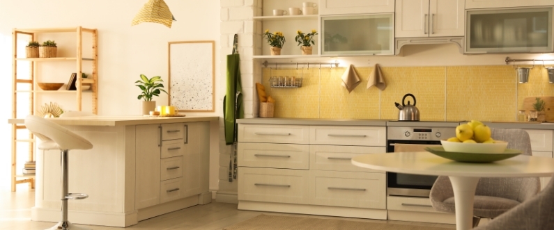 photo of a warmly lit kitchen with mid-century white cabinets and yellow backsplash