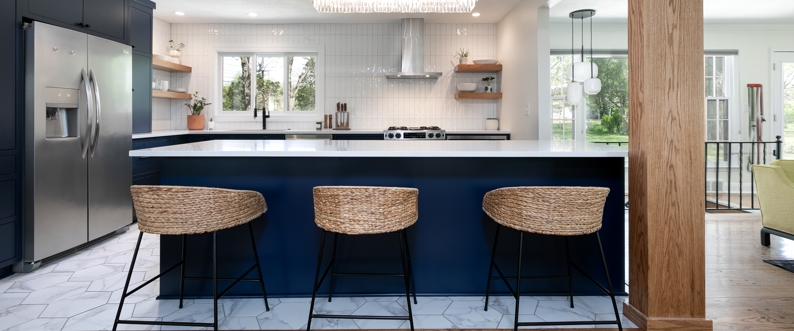 Kitchen with blue island and brown chairs