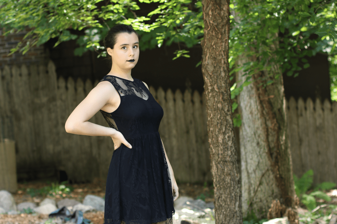person in gothic outfit posing in backyard