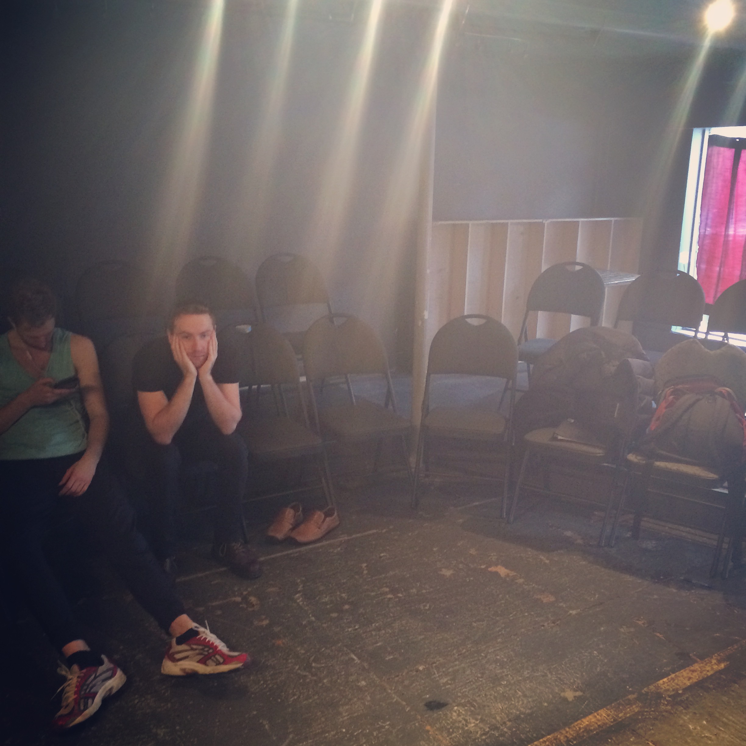 Photo of a sun streaked rehearsal room and two people waiting.