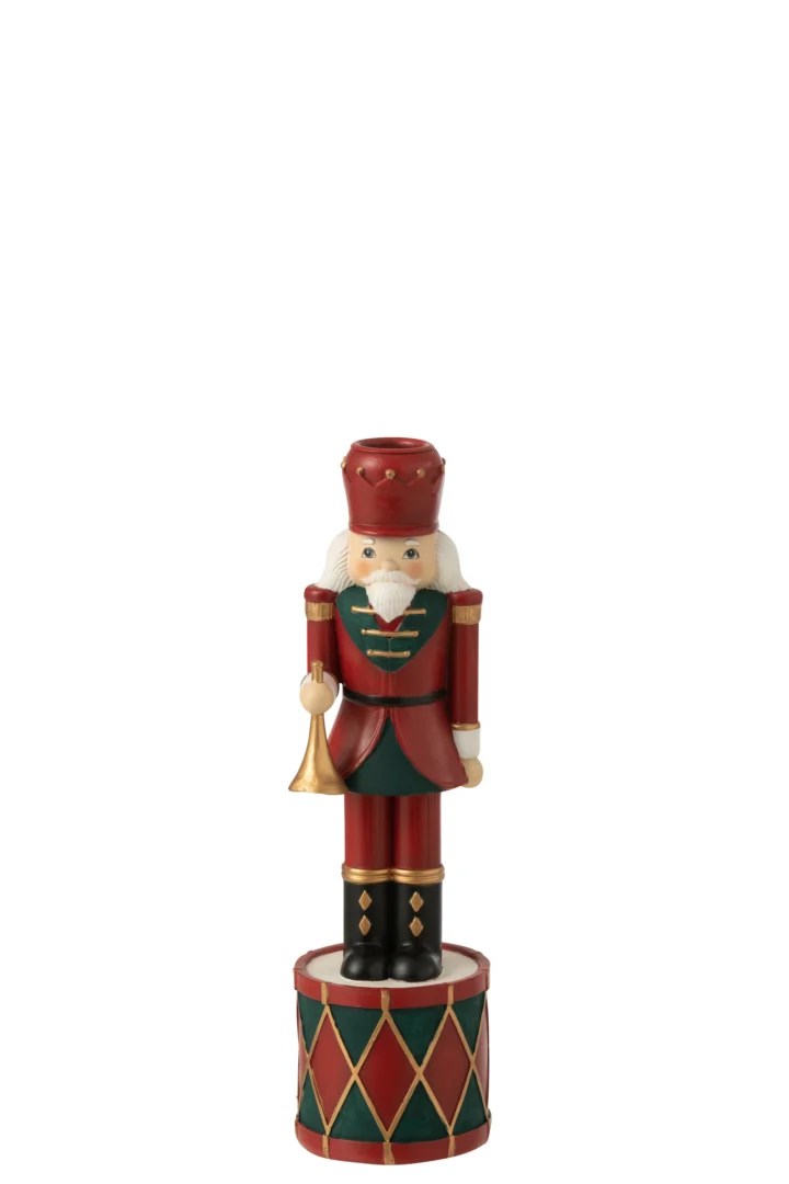 De Kaarsenhouder Notenkraker Hars Rood/Groen Klein is een decoratieve houten notenkraker soldaat in rood en groen, die een trompet vasthoudt en op een ronde voet met ruitpatroon staat.