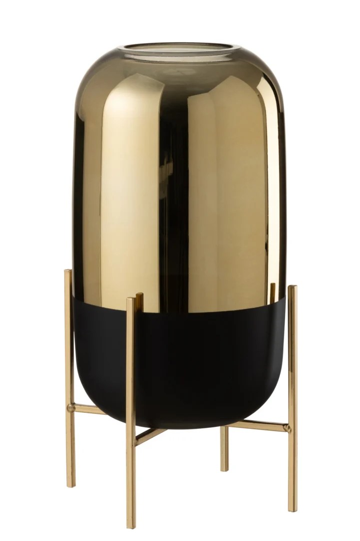 De Kaarsenhouder Orkaan Te Voet Glas Zwart Goud is een hoge, cilindervormige kandelaar met een glanzende gouden afwerking, op een zwarte voet en een goudkleurige metalen standaard voor een moderne, elegante look.