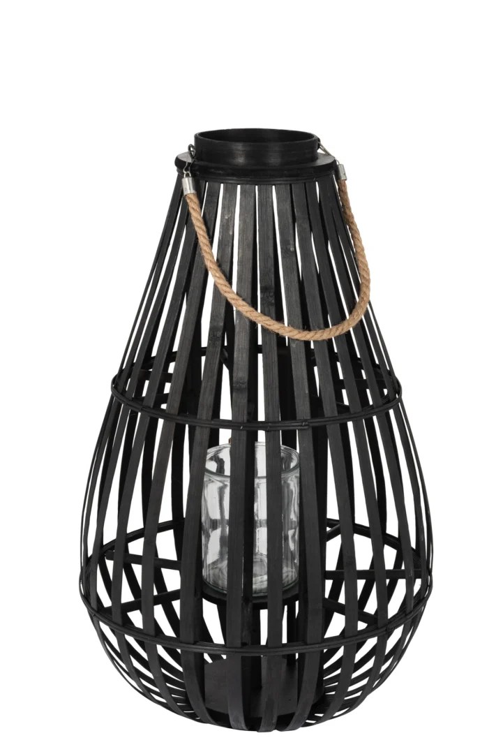 De Kaarsenhouder Lantaarn Druppel Bamboe Zwart Medium is een zwarte kooilantaarn met een ronde basis, verticale lamellen, een handvat van touw aan de bovenkant en een helder glazen houder voor je kaars.