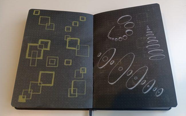 Open black notebook with dotted pages. The left page is filled with overlapping squares drawn in pale-yellow ink, and the right page with white ellipses arranged in curving rows.
