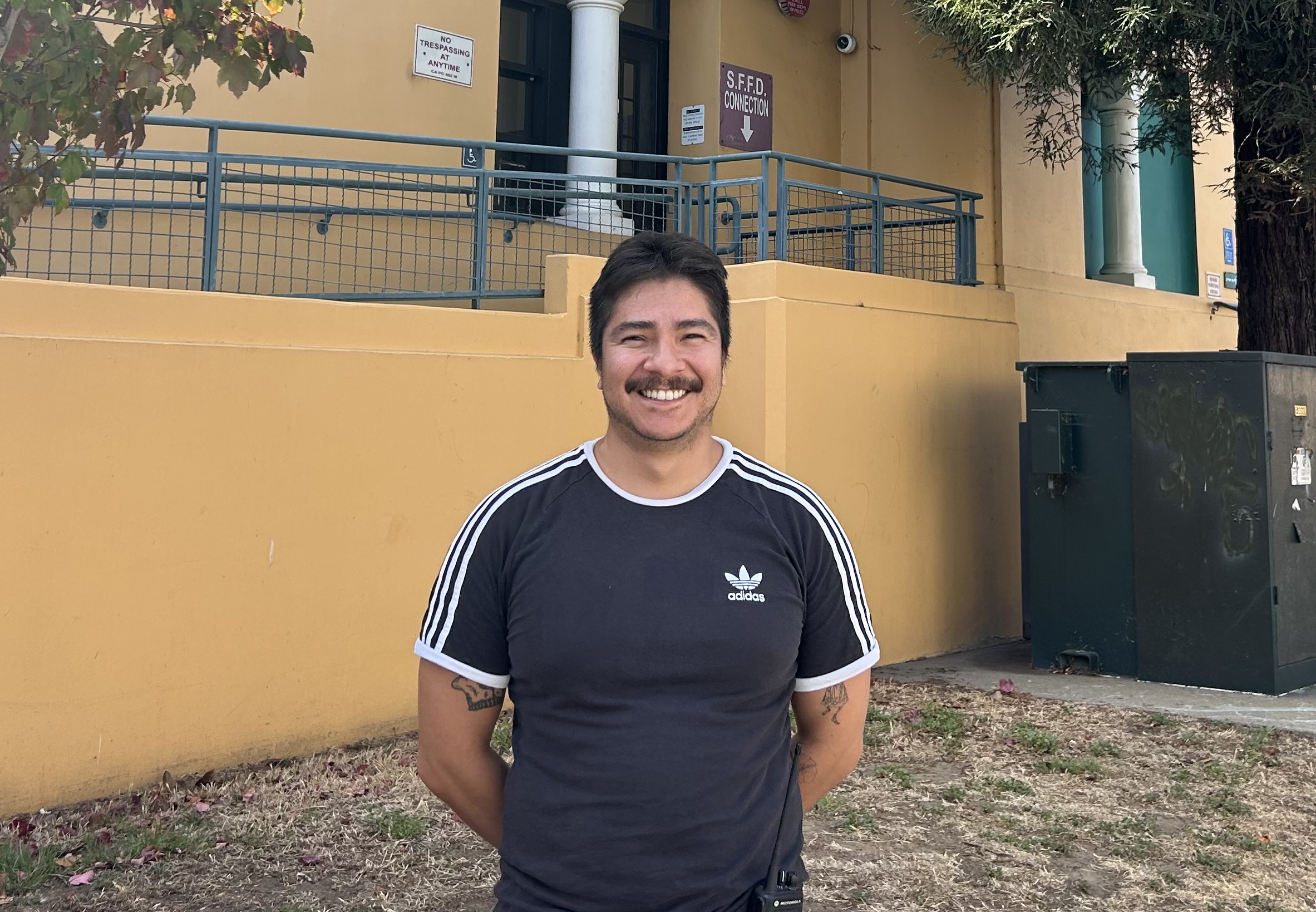 Christopher Herrera stands smiling in front of Everett Middle School.
