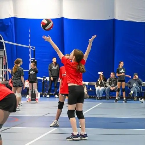 young girl serving a volleyball