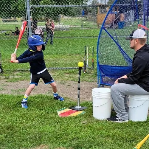 boy swinging bat at a ball on a tee
