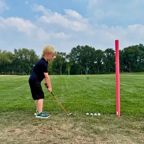 young boy ready to swing at a golf ball
