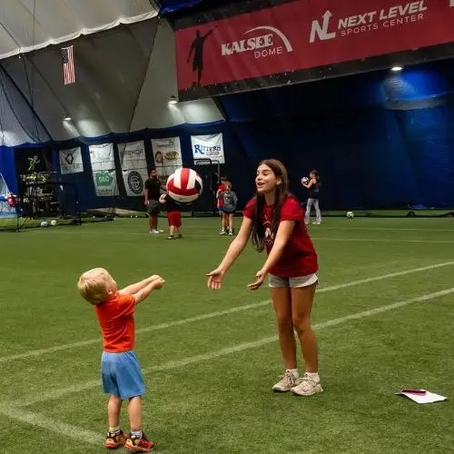 little boy learning how to hit a volleyball