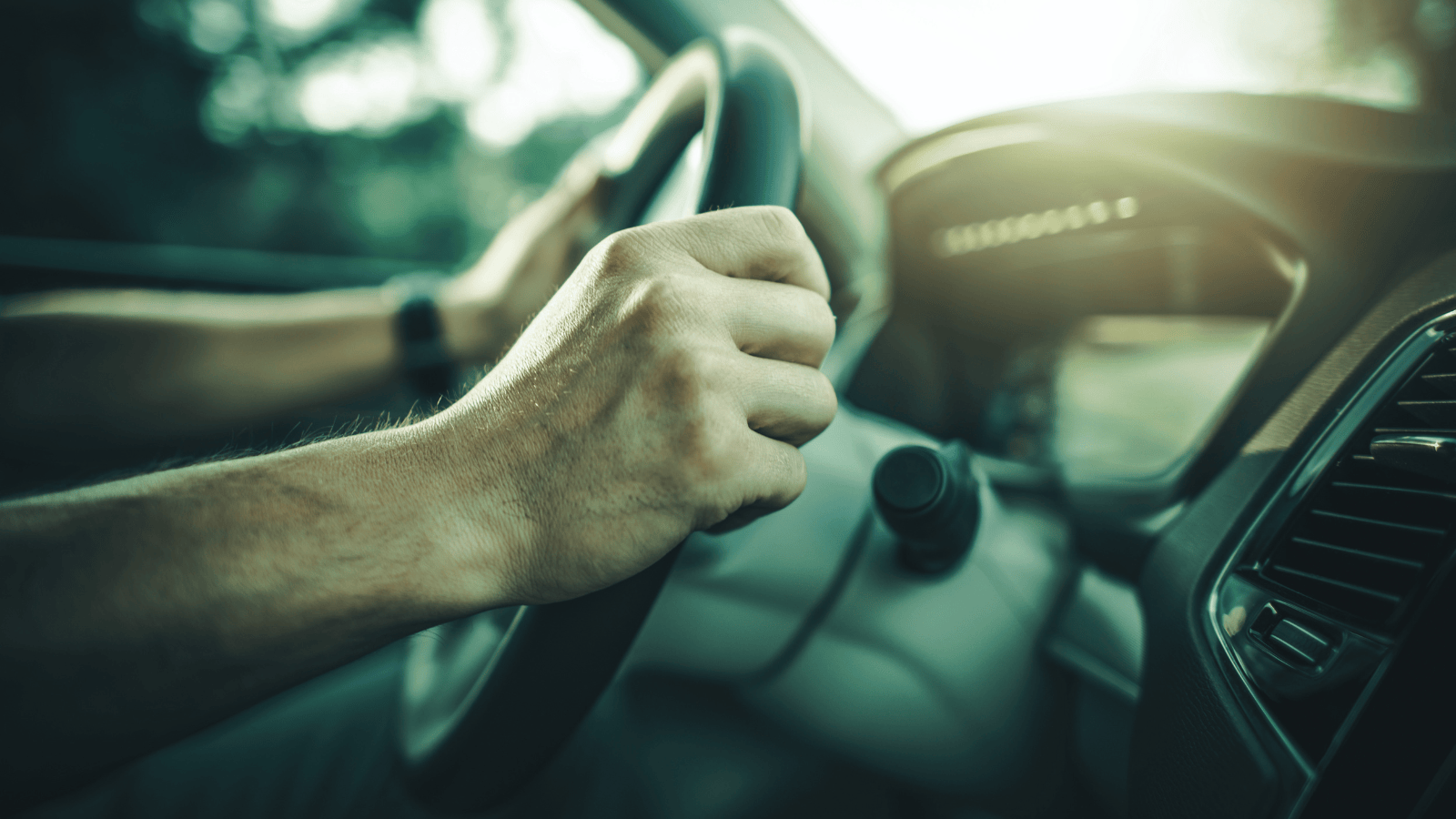 A man's hands on a steering wheel, representing taking back control of your happiness without alcohol