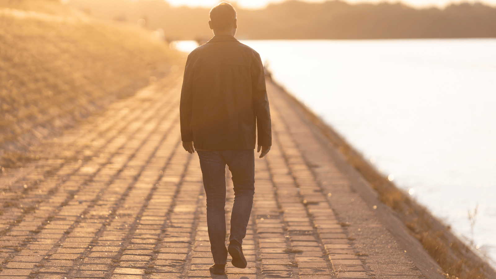 A man walking away, down a brick sidewalk next to the water. Symbolizes walking away from a relationship that was no longer healthy.