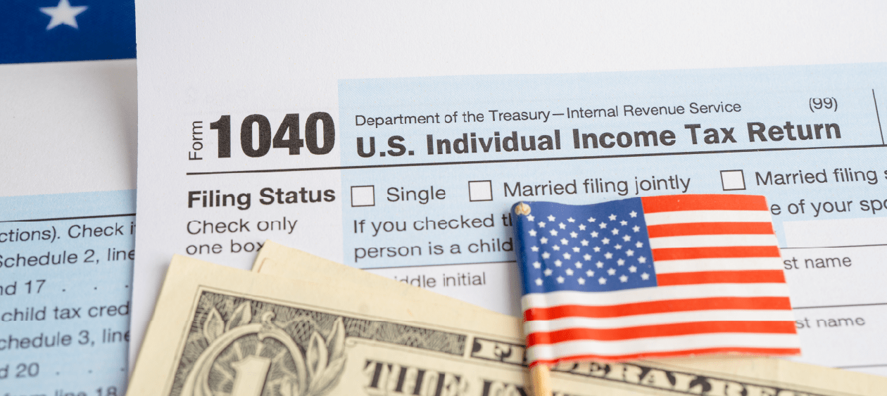 IRS Form 1040 with US flag — Nolly explains ITIN exceptions to the tax return filing requirement