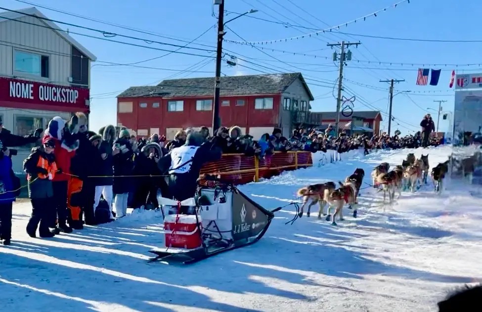 Dallas Seavey running beside his dogs for the final stretch