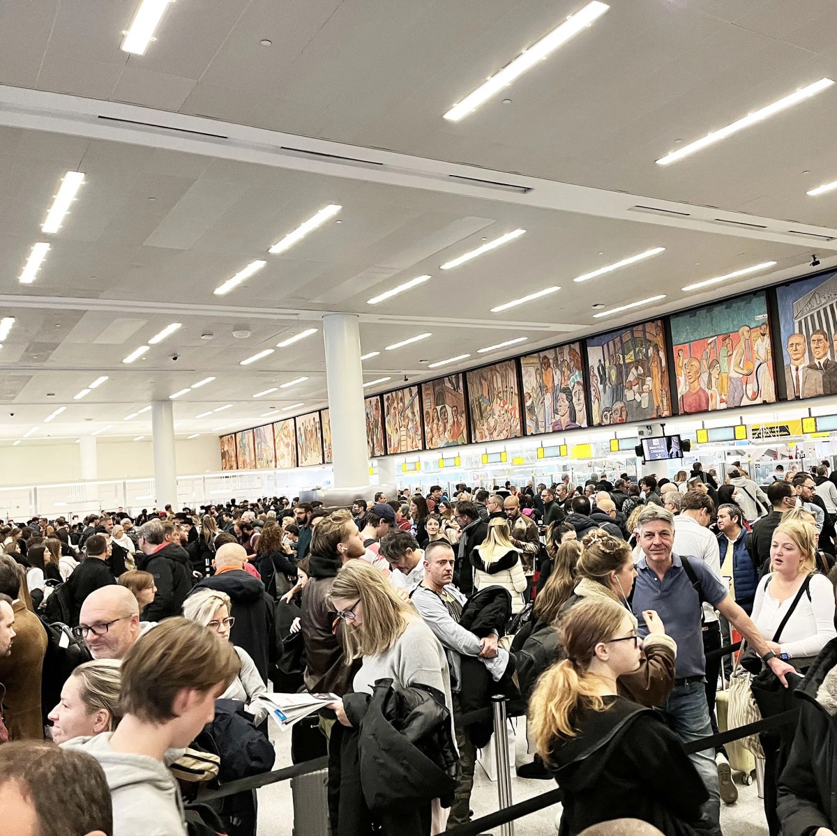 Afbeelding van de immigratiehal op JFK, helemaal vol met rijen mensen ter grootte van een voetbalveld.
