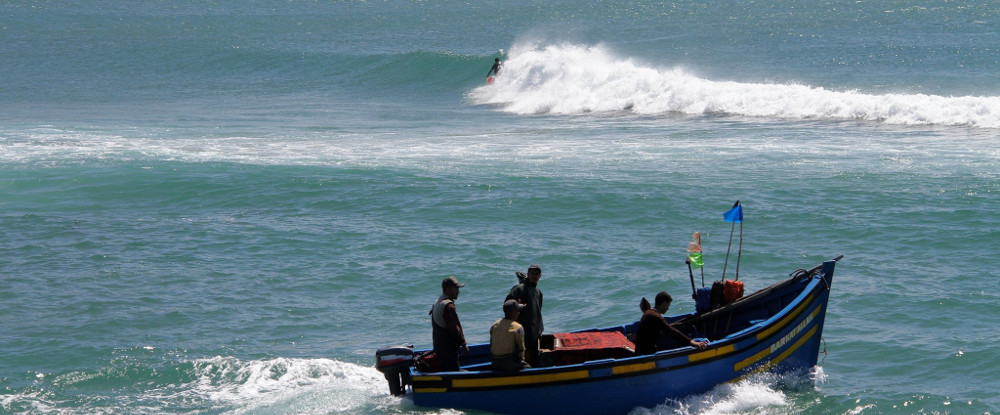 Surfer on a wave and a boat