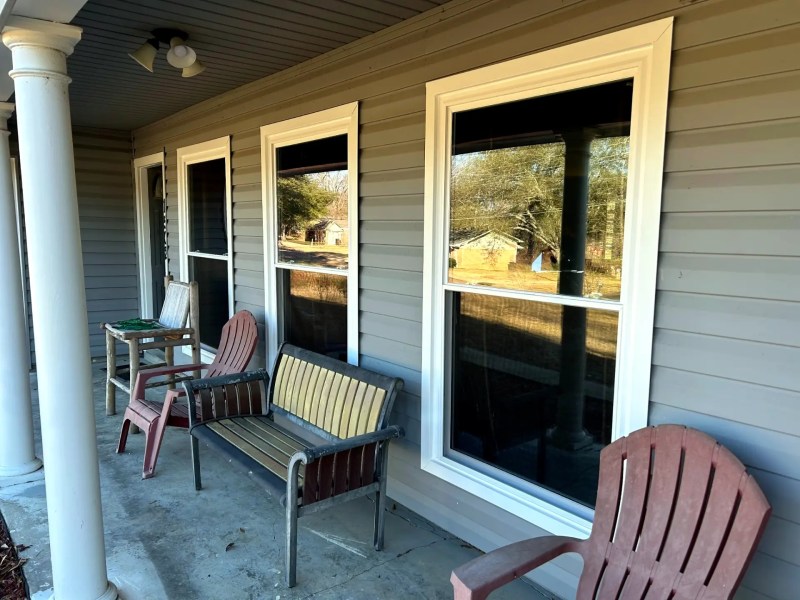 New vinyl replacement window on a home in Meridian, MS with blue sky and trees in the background