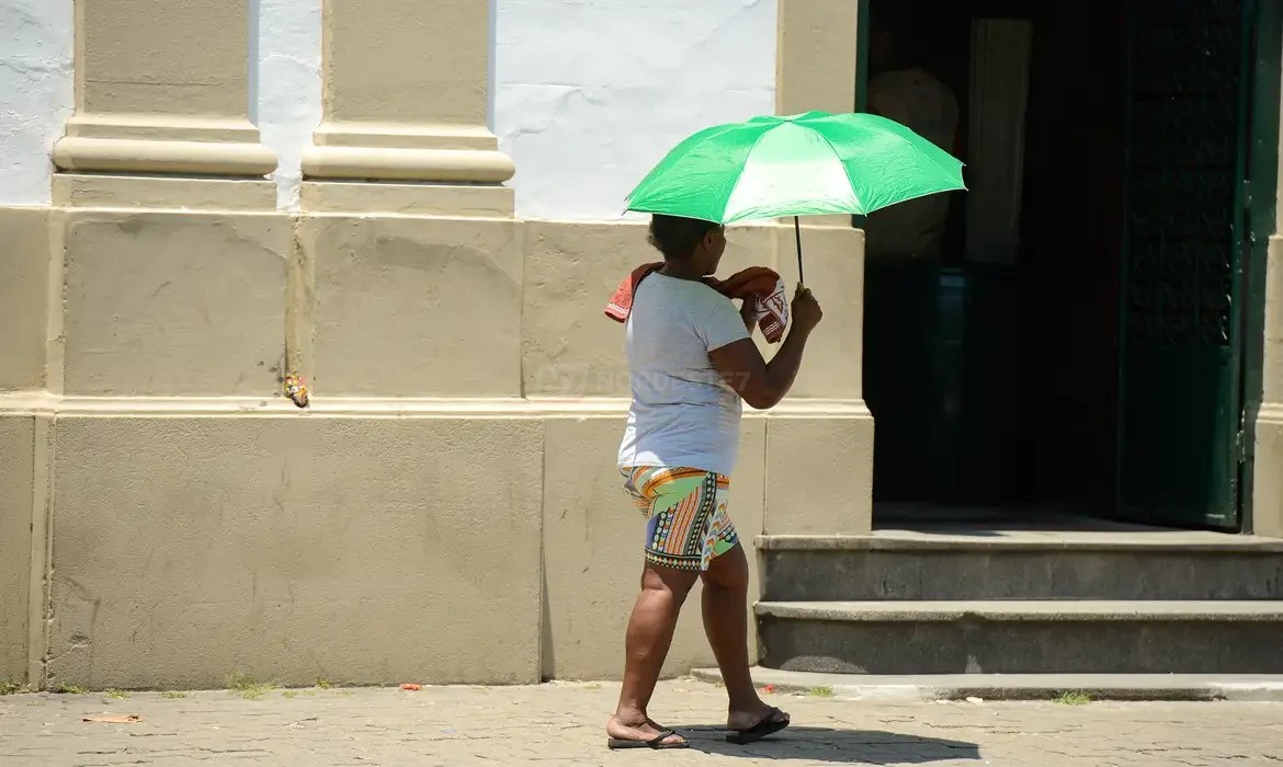 Termômetro de rua marcando alta temperatura sob sol forte durante onda de calor extremo associada ao Super El Niño.