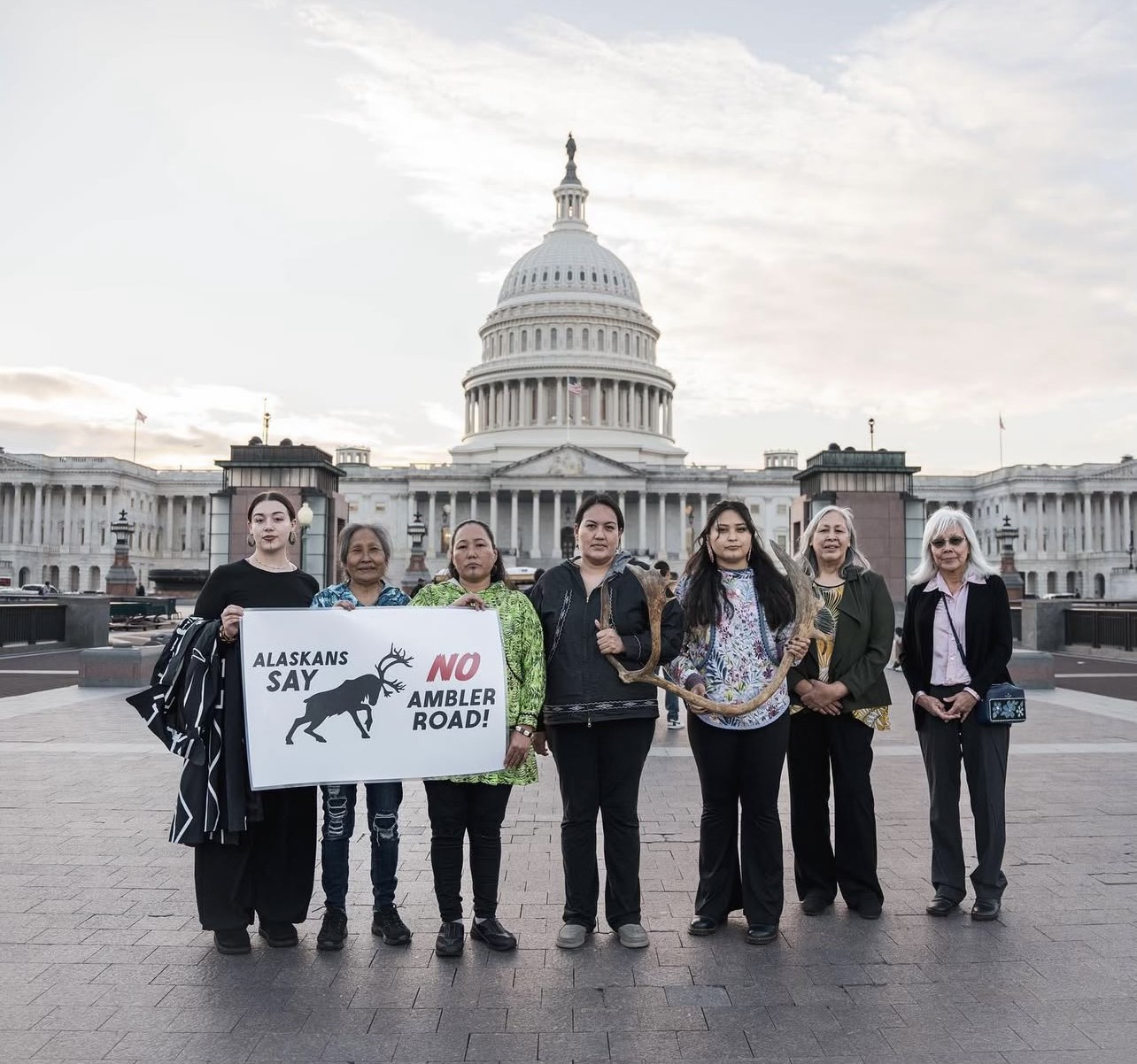 A group of seven Alaska Native women are somber as they look to the camera for a photo outside the Capitol in Washington D.C.