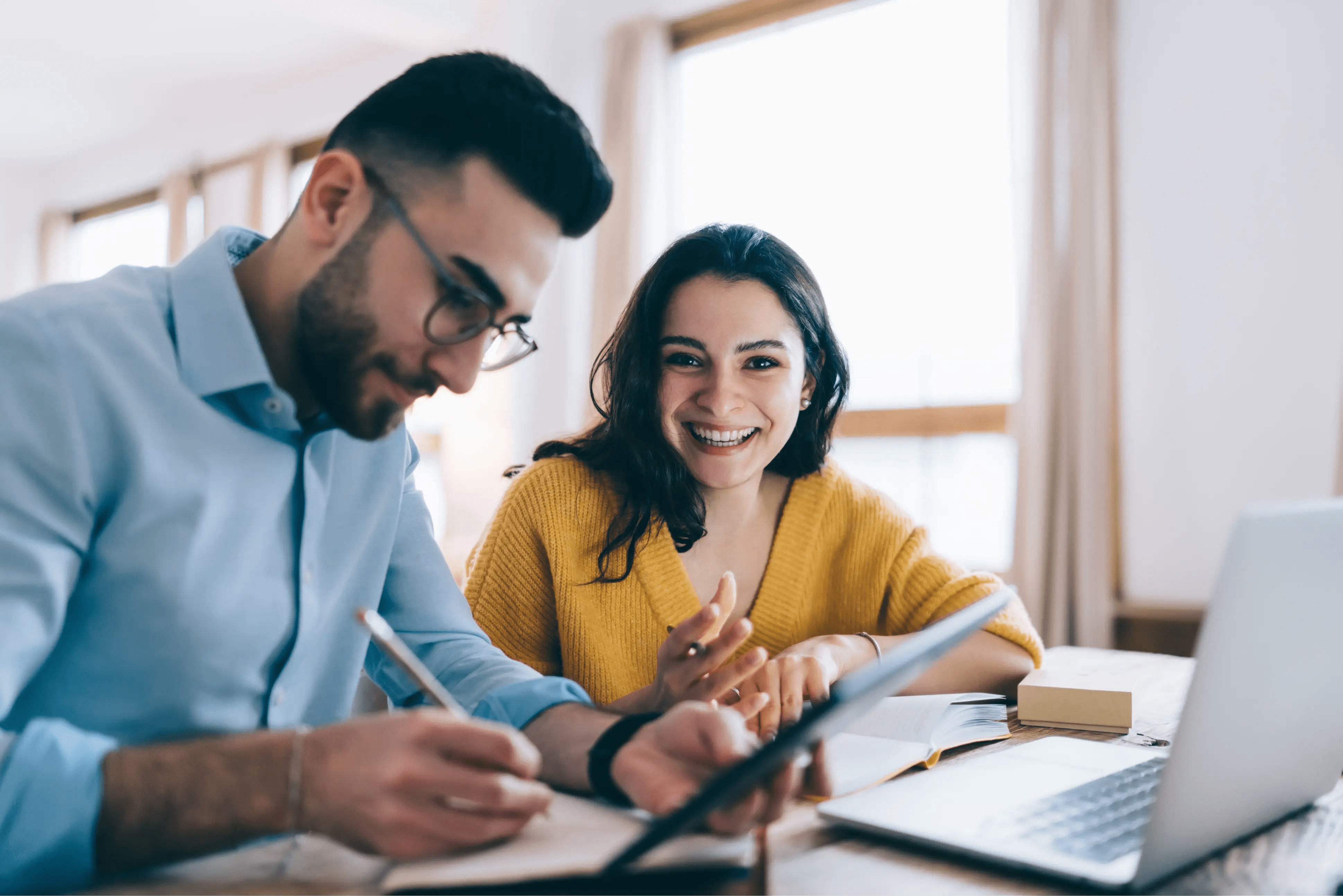 Young man and woman using a laptop to take part in an online course