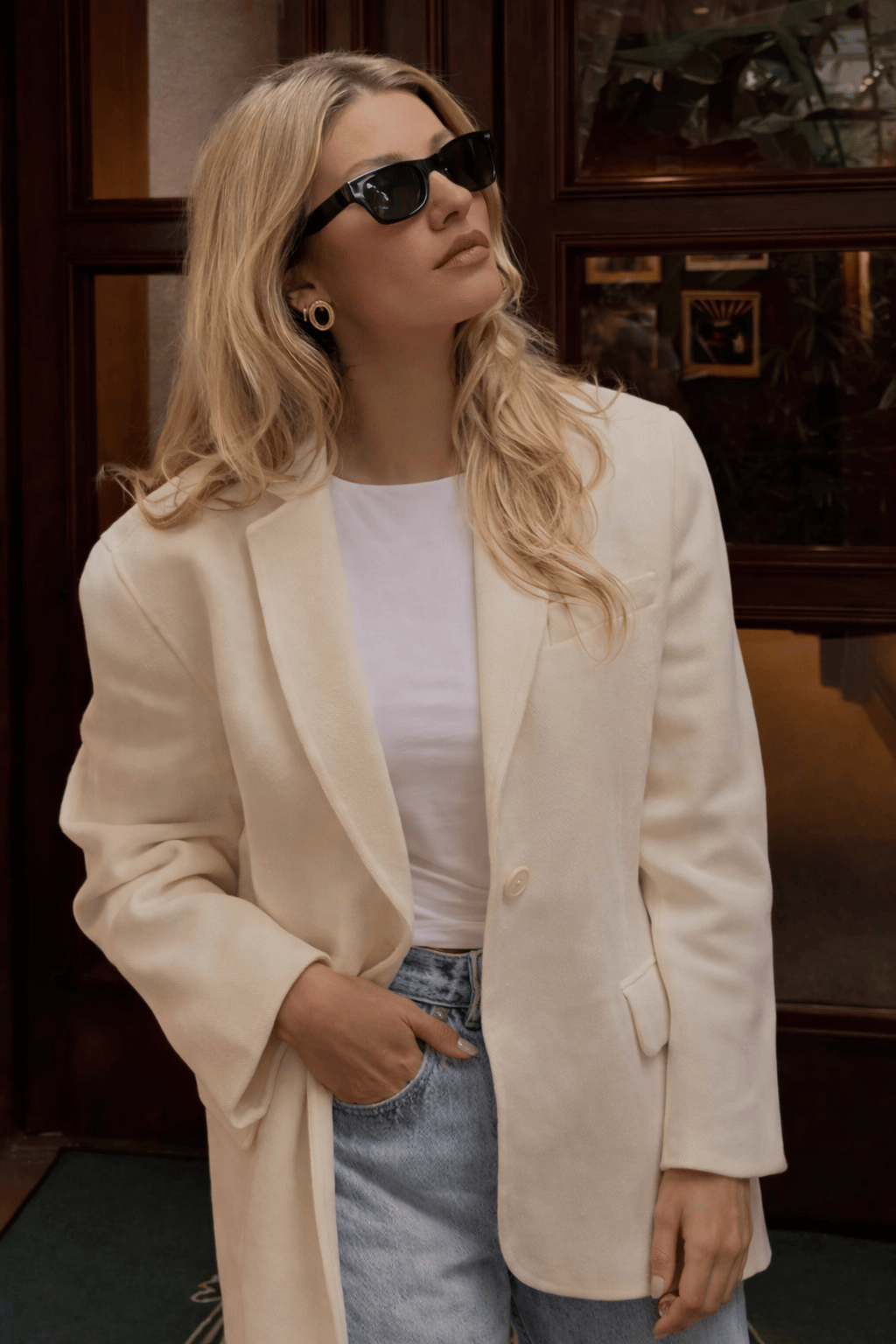 blonde hair woman in white blazer and jeans