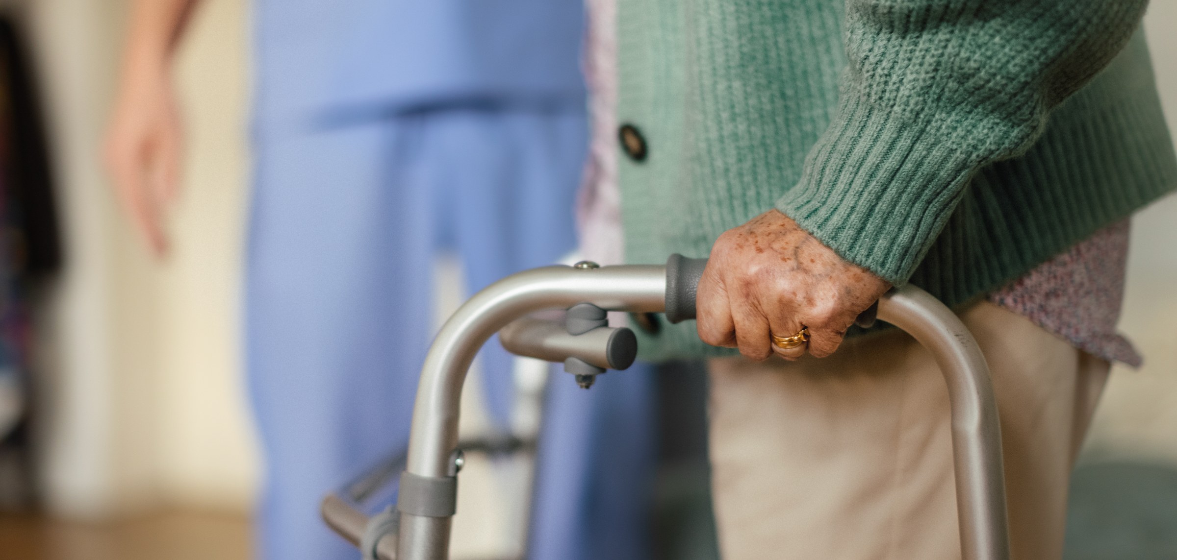 Close view of an older woman holding a walker.
