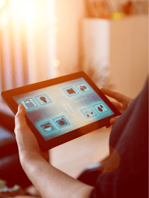Person using a tablet to control smart home devices like lights and appliances