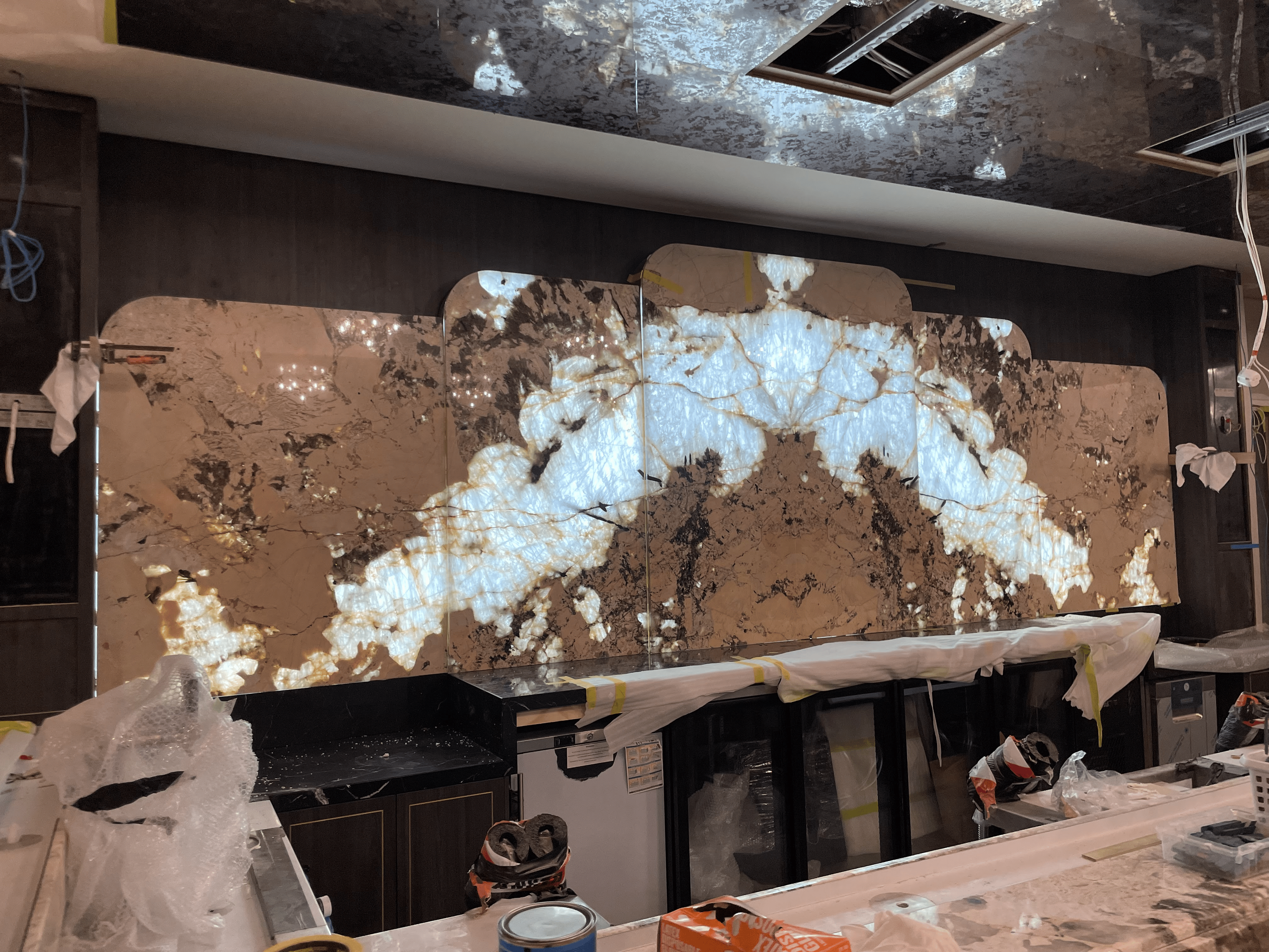 Pink Patagonia quartzite backlit splashback being installed behind the GPO bar