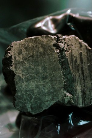 The meteorite labeled ALH84001 is held in the hand of a scientist at a Johnson Space Center lab in Houston.