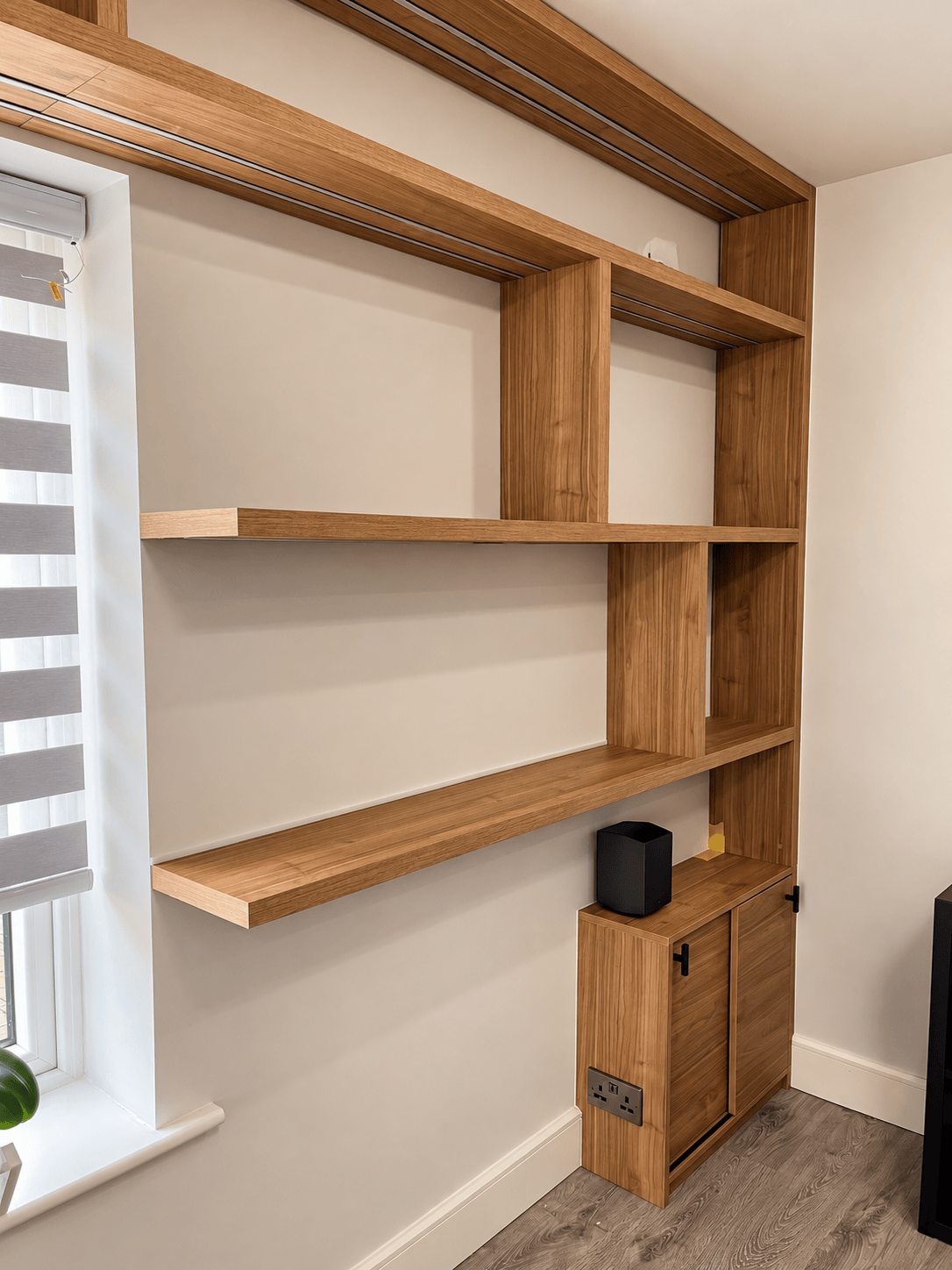 Made-to-measure alcove study desk with slatted wood wall panels and integrated warm LED strip lighting for a bedroom office.