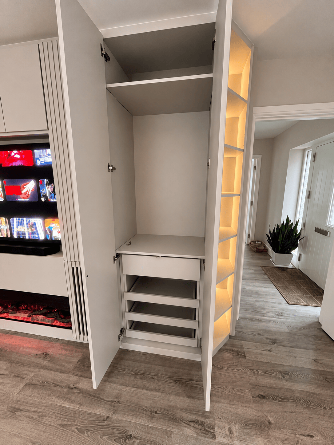 Internal storage drawers and shelving unit inside a custom floor-to-ceiling wardrobe designed by a luxury joinery in Ireland.