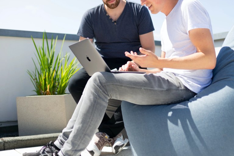 Deux assistants virtuels travaillant sur leur ordinateur portable sous le soleil