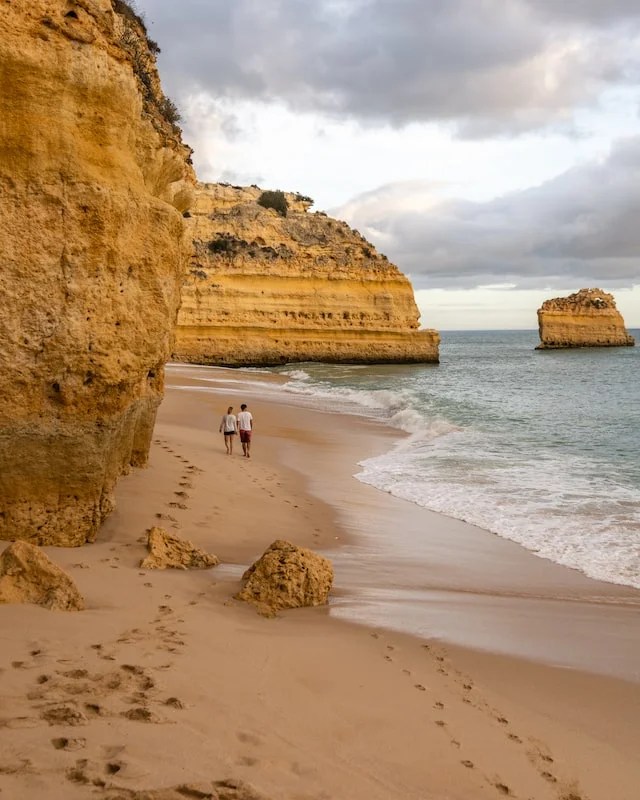 un couple qui marche sur la plage dans le sud du Portugal