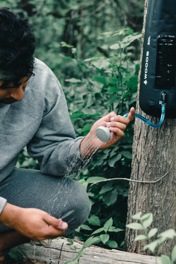 homme qui se sert d'une douche solaire portable