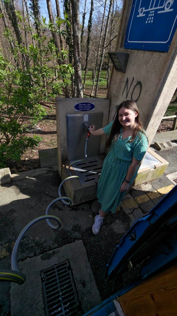 femme qui rempli les réservoirs d'eau avec de l'eau potable