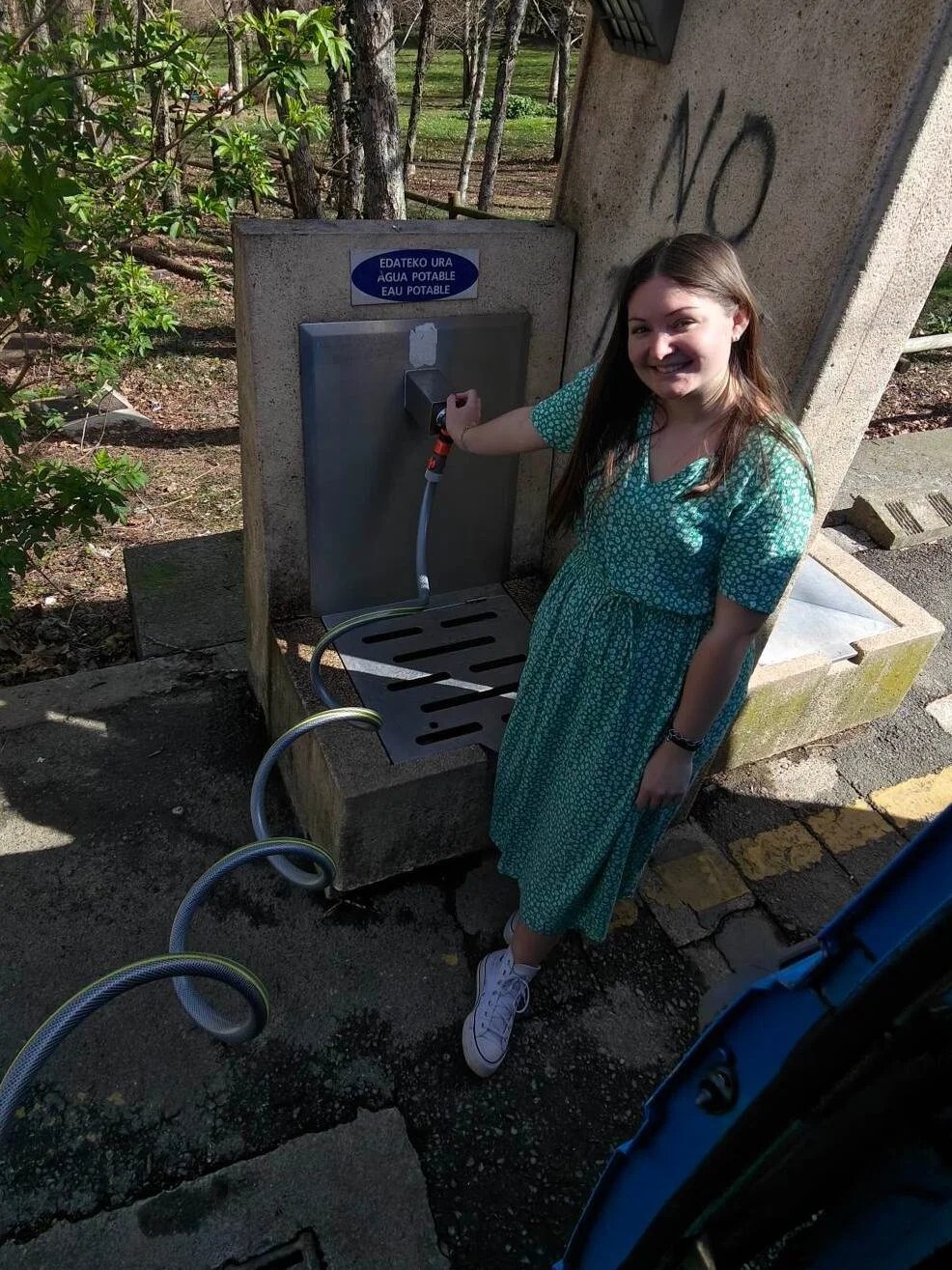 femme qui rempli les réservoirs d'eau avec de l'eau potable