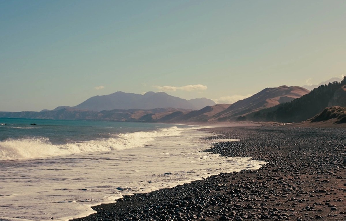 Clean pebble beach with mountains