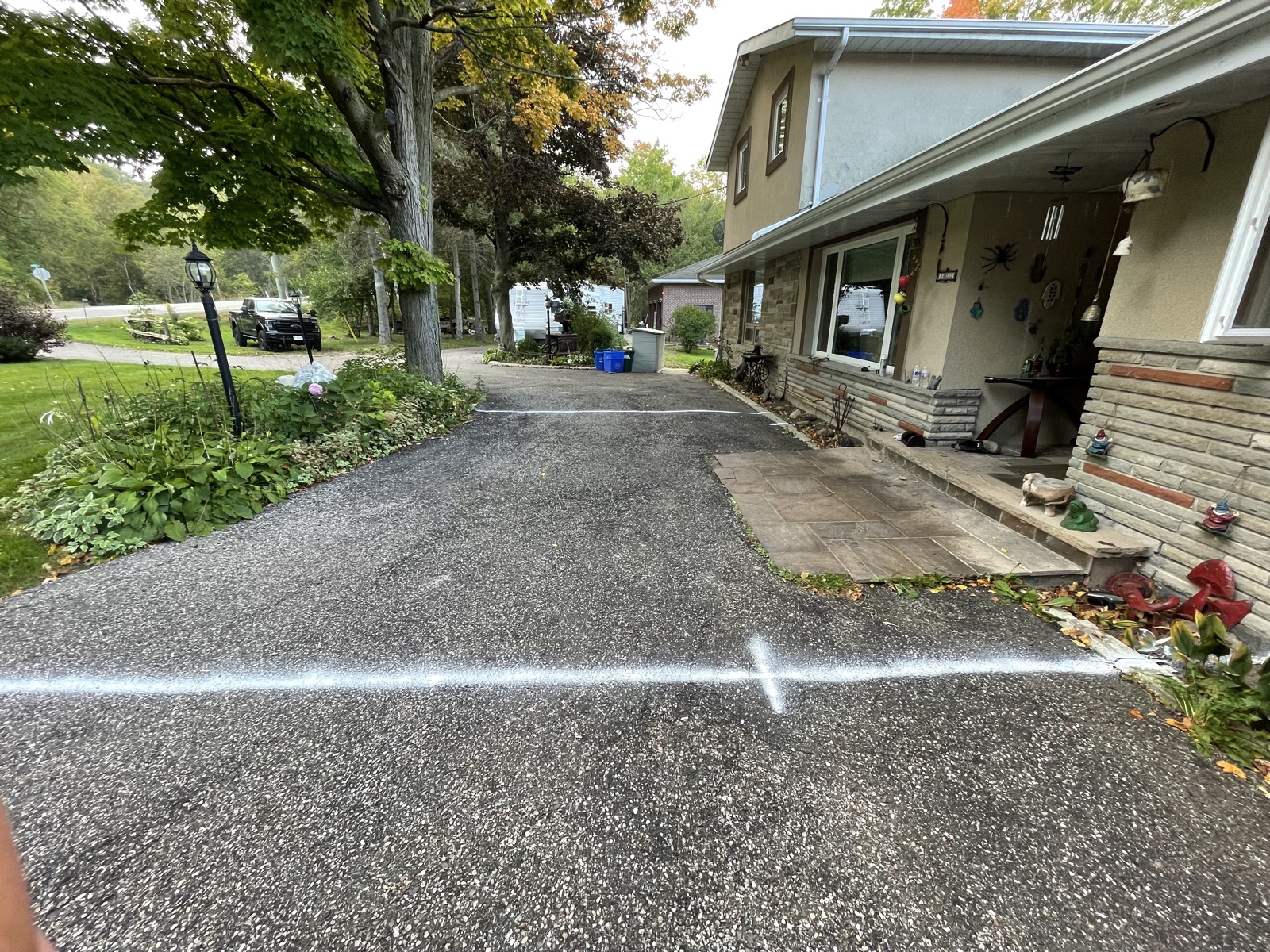 Before photo of asphalt driveway with chalk-marked layout for interlocking installation — OCM Excavation, Toronto/GTA