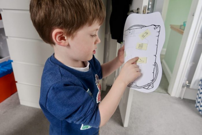 A boy pointing at pictures on a treasure map