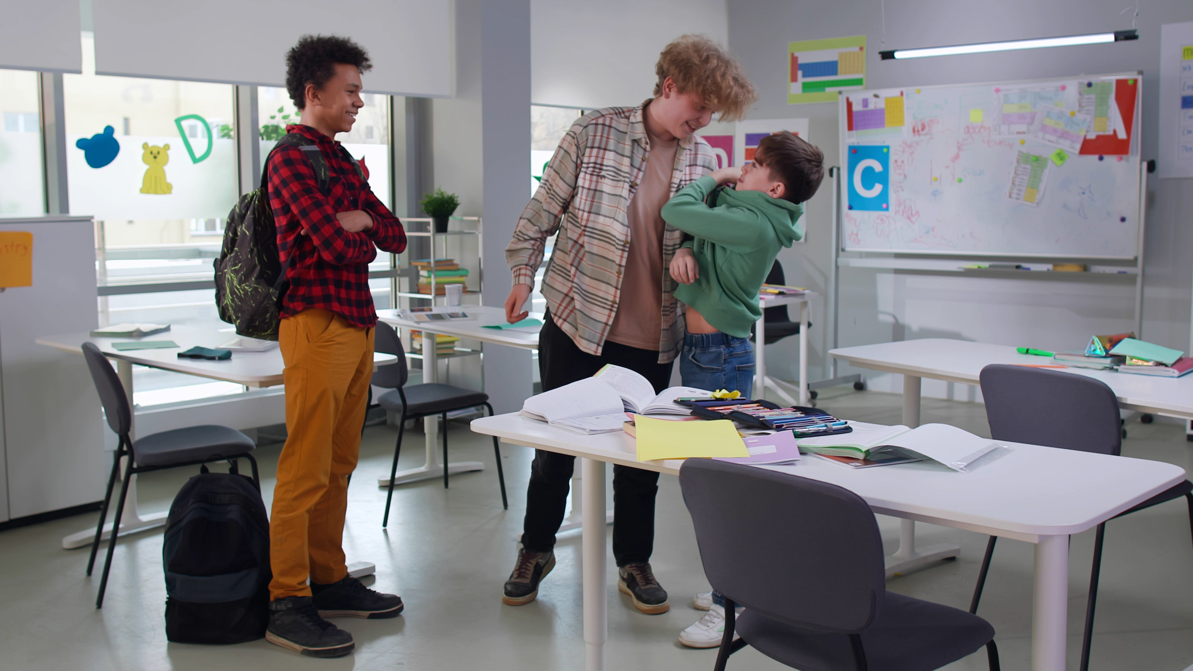 Students bullying boy in classroom