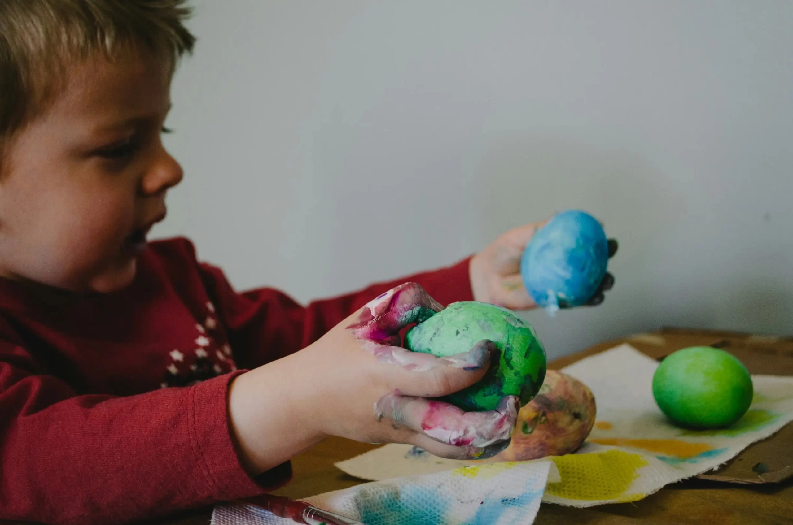 Child exploring creativity while playing with colorful painted clay