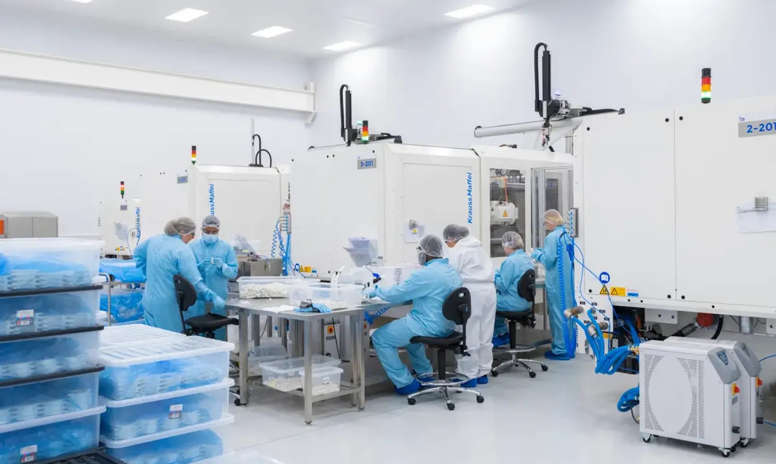 Cleanroom production area where gowned operators handle electrostatic-sensitive assembly work
