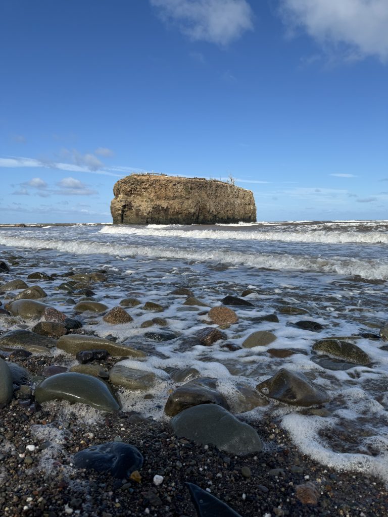 galets sur la plage de pokeshaw avec le rocher de pokeshaw en arrière