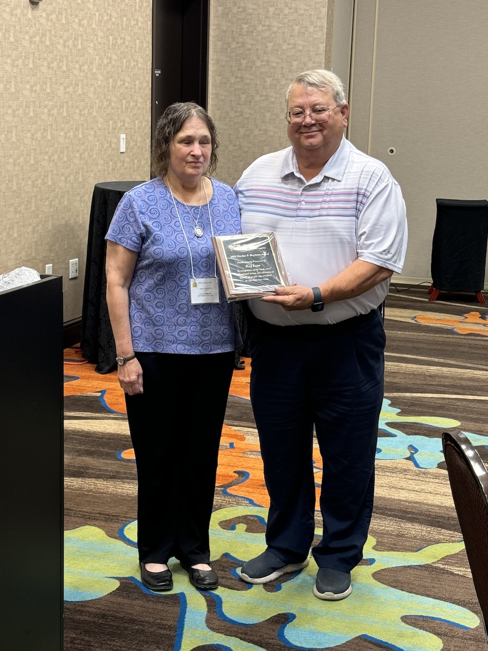 Vicki Golightly presenting the Gordon P. Stephens award to Tom Love honoring the late Kay Love.