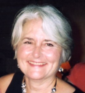 Lane Goddard Bio Photo, a white woman with short grey hair and a small