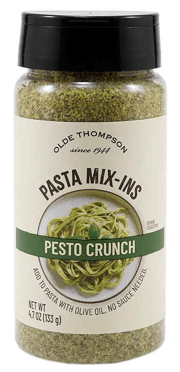 A jar of Olde Thompson Pasta Mix-Ins labeled Pesto Crunch, featuring an image of pesto pasta on the front. The jar contains 4.7 oz (133 g) of the pasta seasoning mix.
