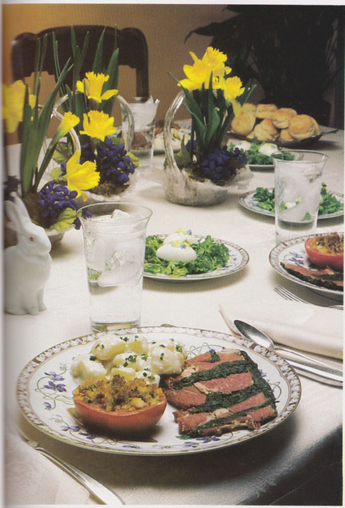 Elegant Easter dinner table with yellow daffodils, stuffed ham, roasted vegetables, and formal place settings in Maryland